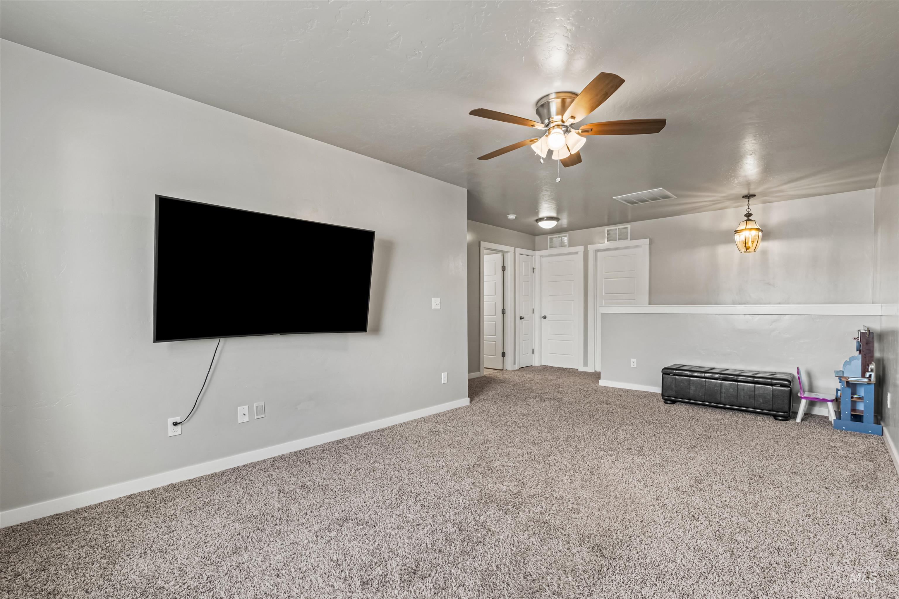 12030 West Abram Street Boise, ID 83713 - Photo 19 of 26 Unfurnished living room with carpet and a ceiling fan