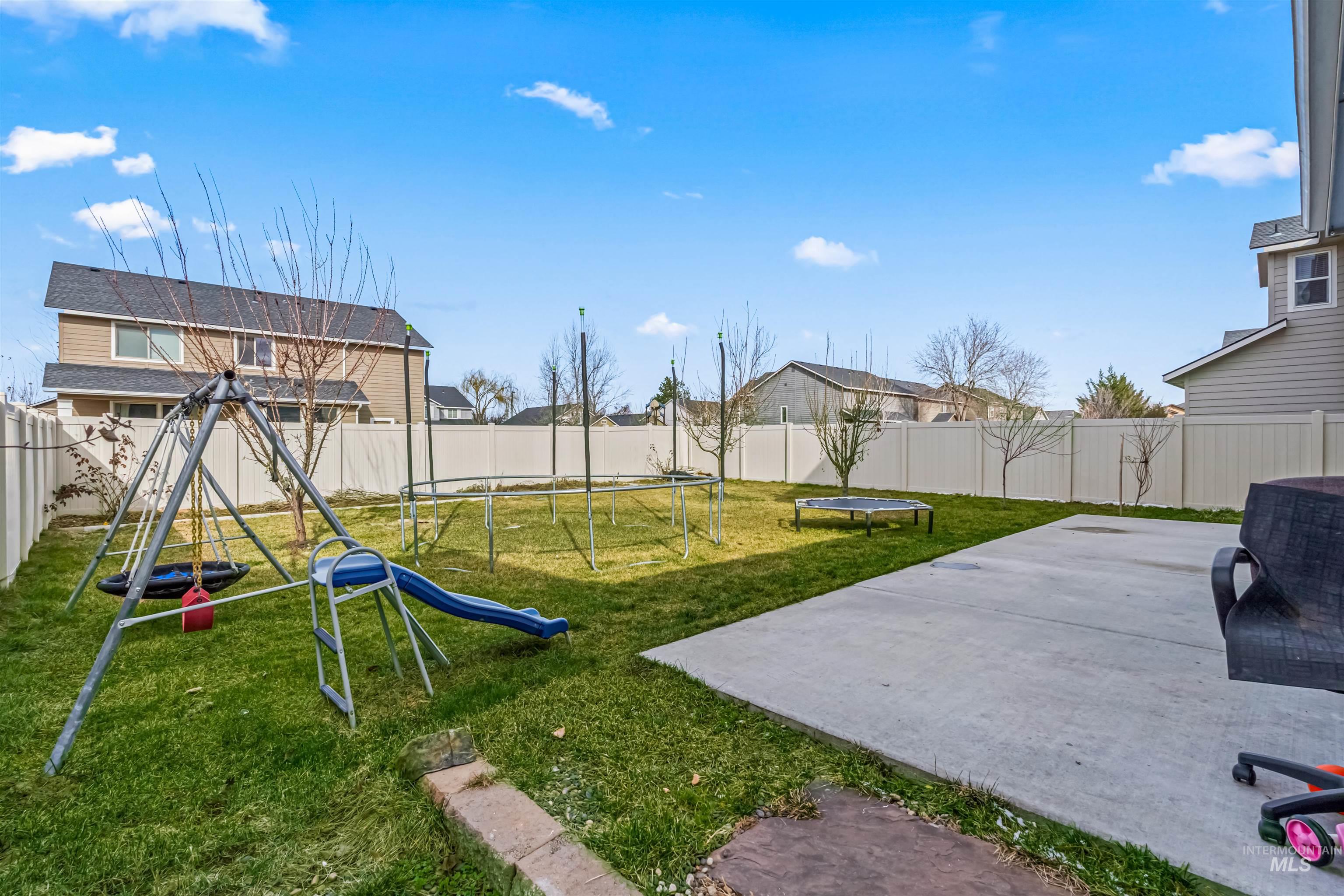 12030 West Abram Street Boise, ID 83713 - Photo 25 of 26 Fenced backyard featuring a trampoline, a playground, and a patio area