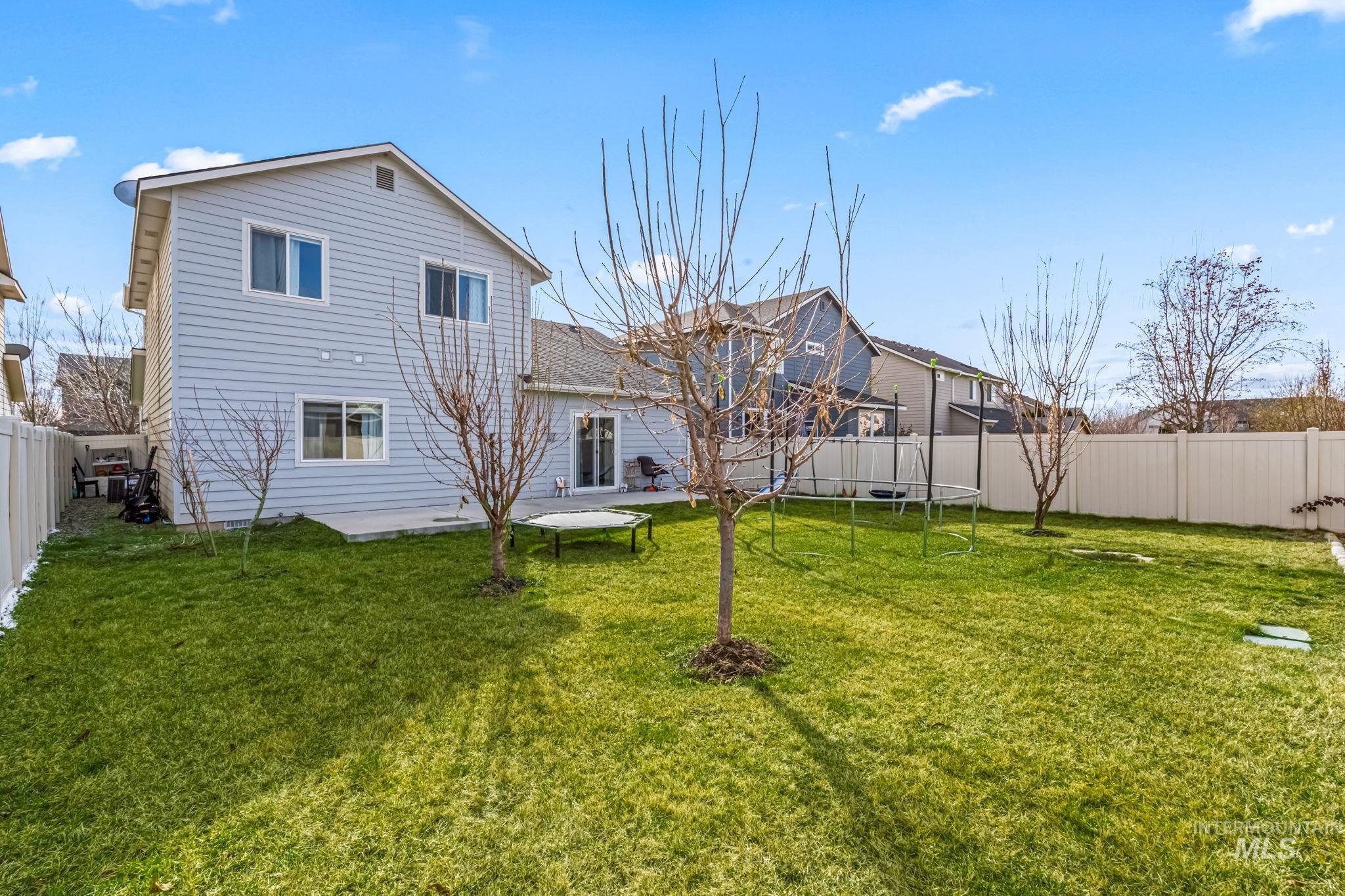 12030 West Abram Street Boise, ID 83713 - Photo 26 of 26 Back of property featuring a fenced backyard, a patio area, and a trampoline