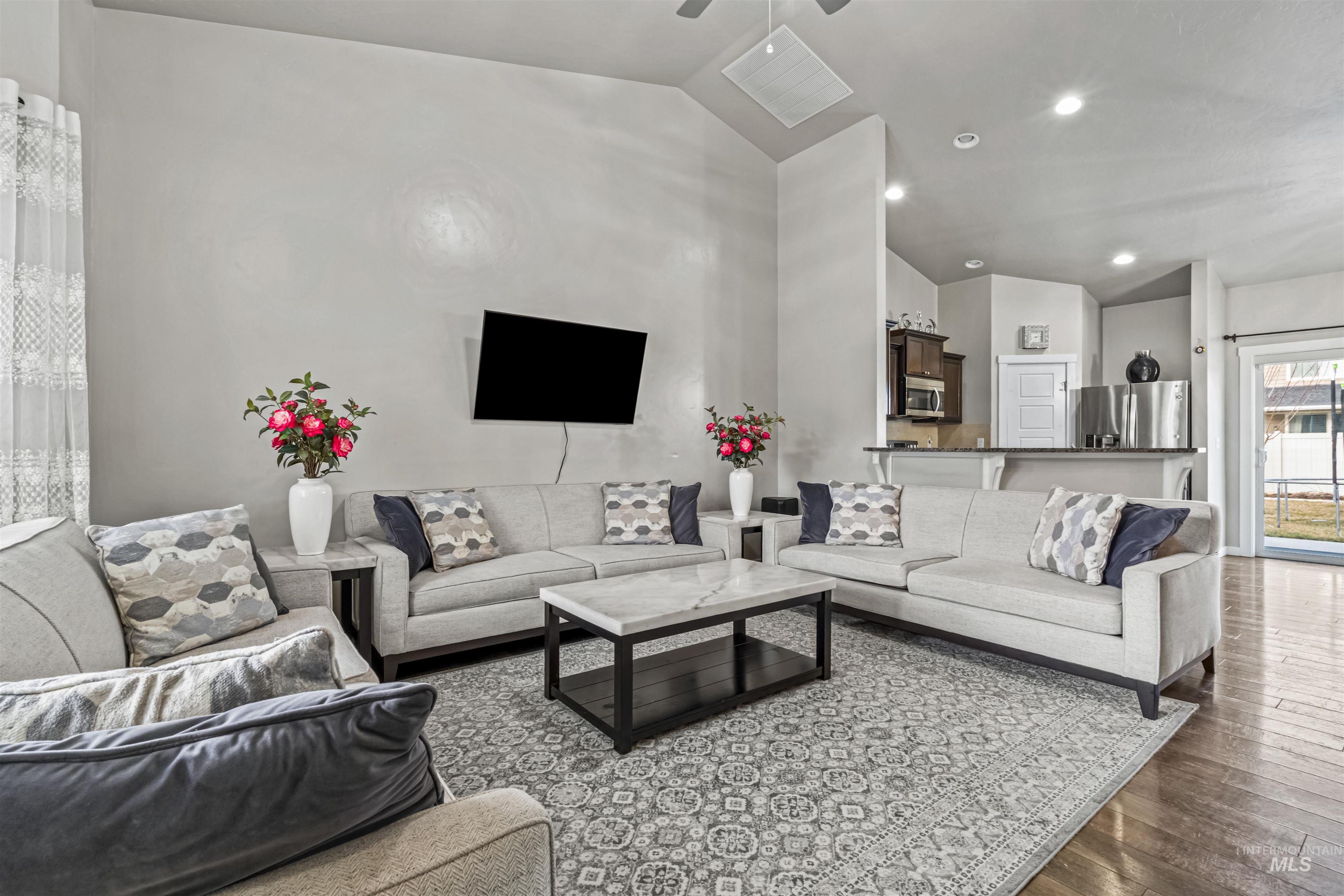 12030 West Abram Street Boise, ID 83713 - Photo 4 of 26 Living area with vaulted ceiling, wood-type flooring, and a ceiling fan