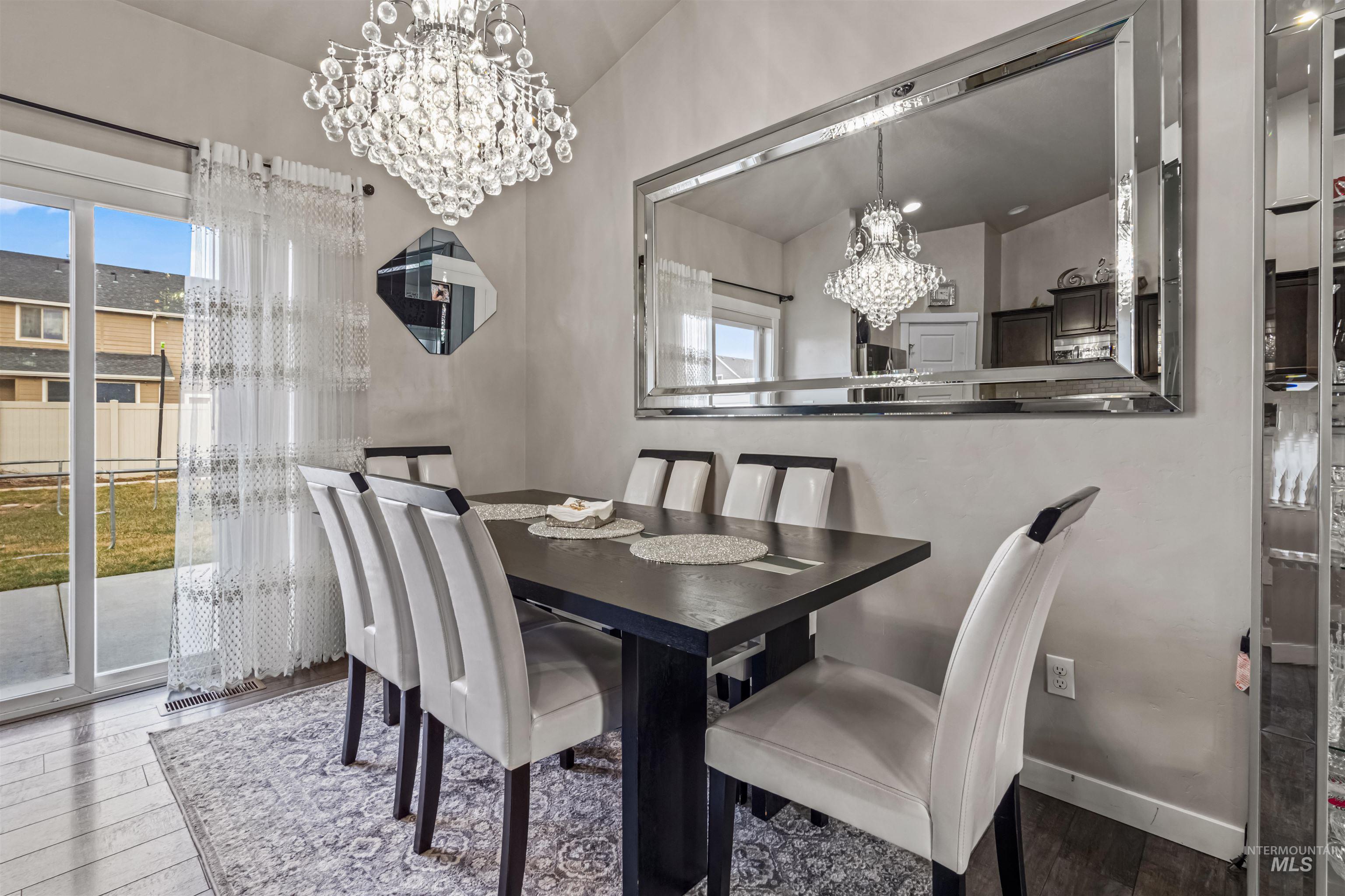 12030 West Abram Street Boise, ID 83713 - Photo 10 of 26 Dining space with suspended lighting, vaulted ceiling, wood finished floors, and plenty of natural light