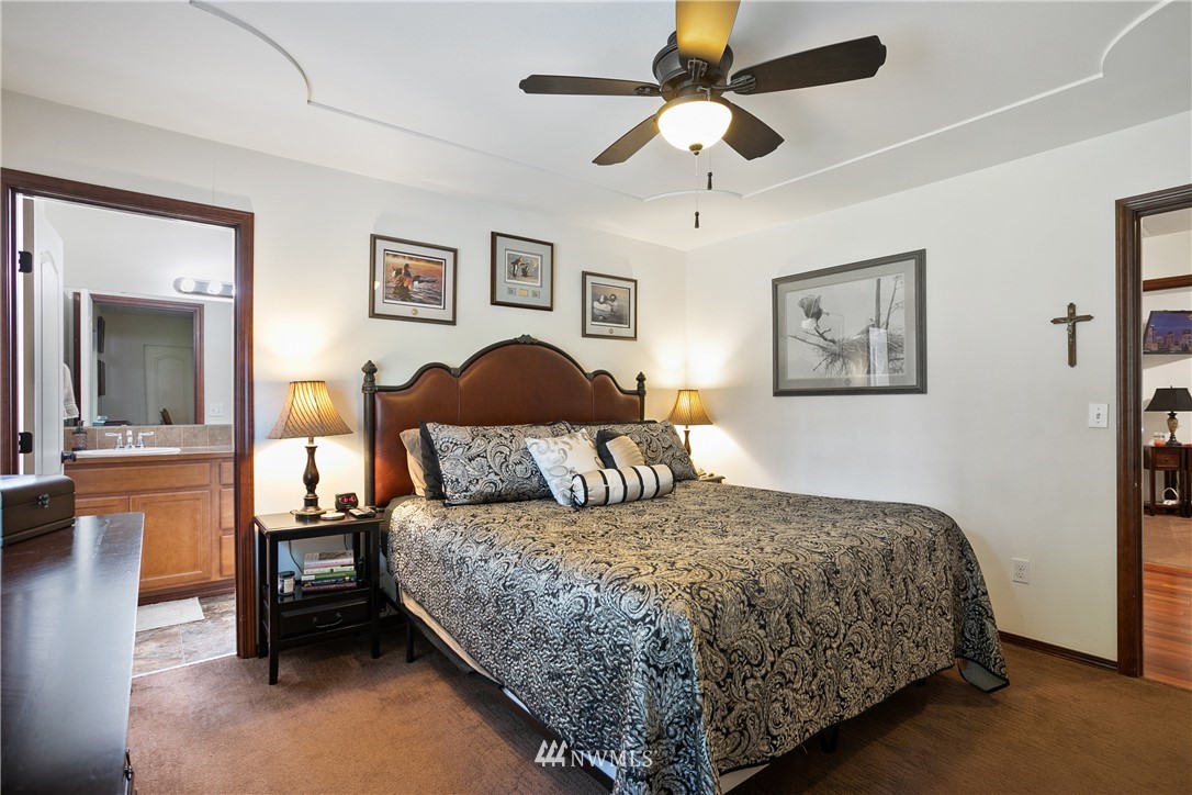 5129 180th Trail Southwest Rochester, WA 98579 - Photo 14 of 22 a bedroom with a large bed and a chandelier