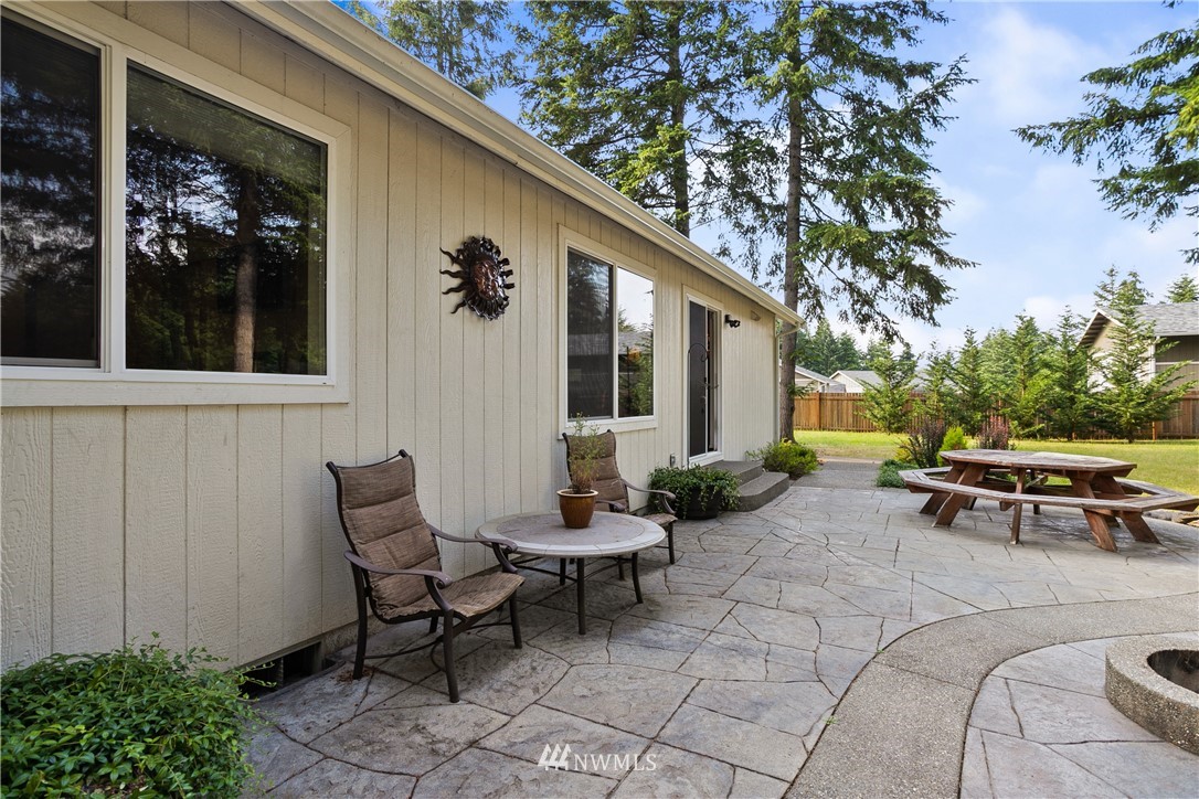 5129 180th Trail Southwest Rochester, WA 98579 - Photo 16 of 22 a view of a patio with table and chairs potted plants and floor to ceiling window and potted plants