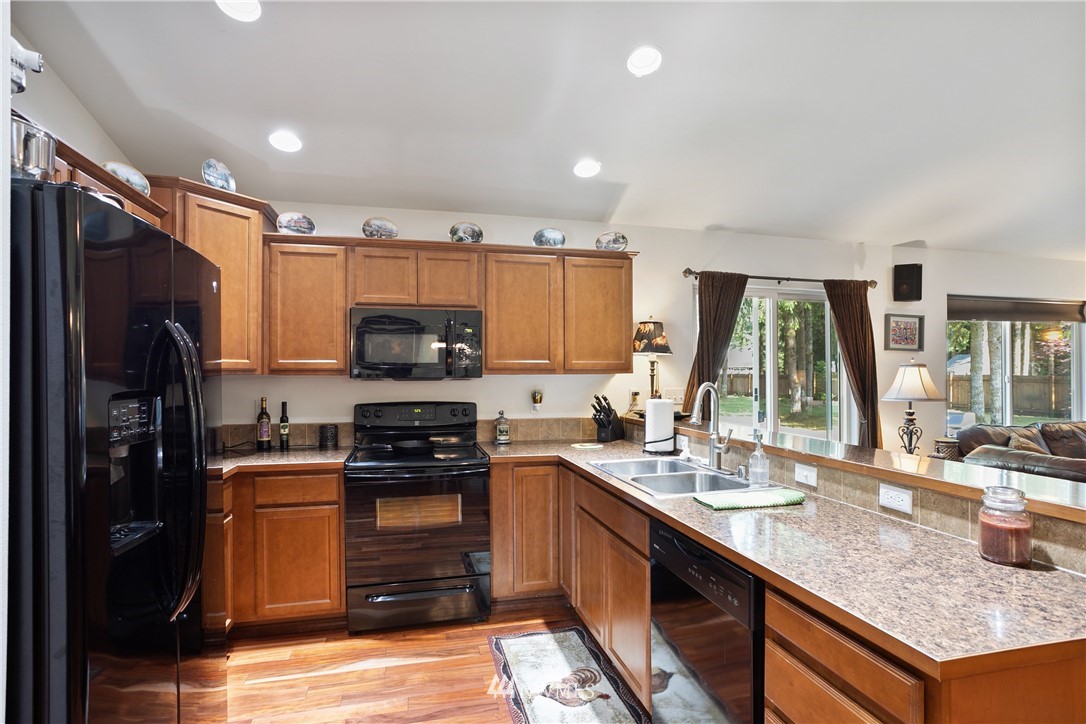 5129 180th Trail Southwest Rochester, WA 98579 - Photo 7 of 22 a kitchen with kitchen island granite countertop a stove sink and refrigerator