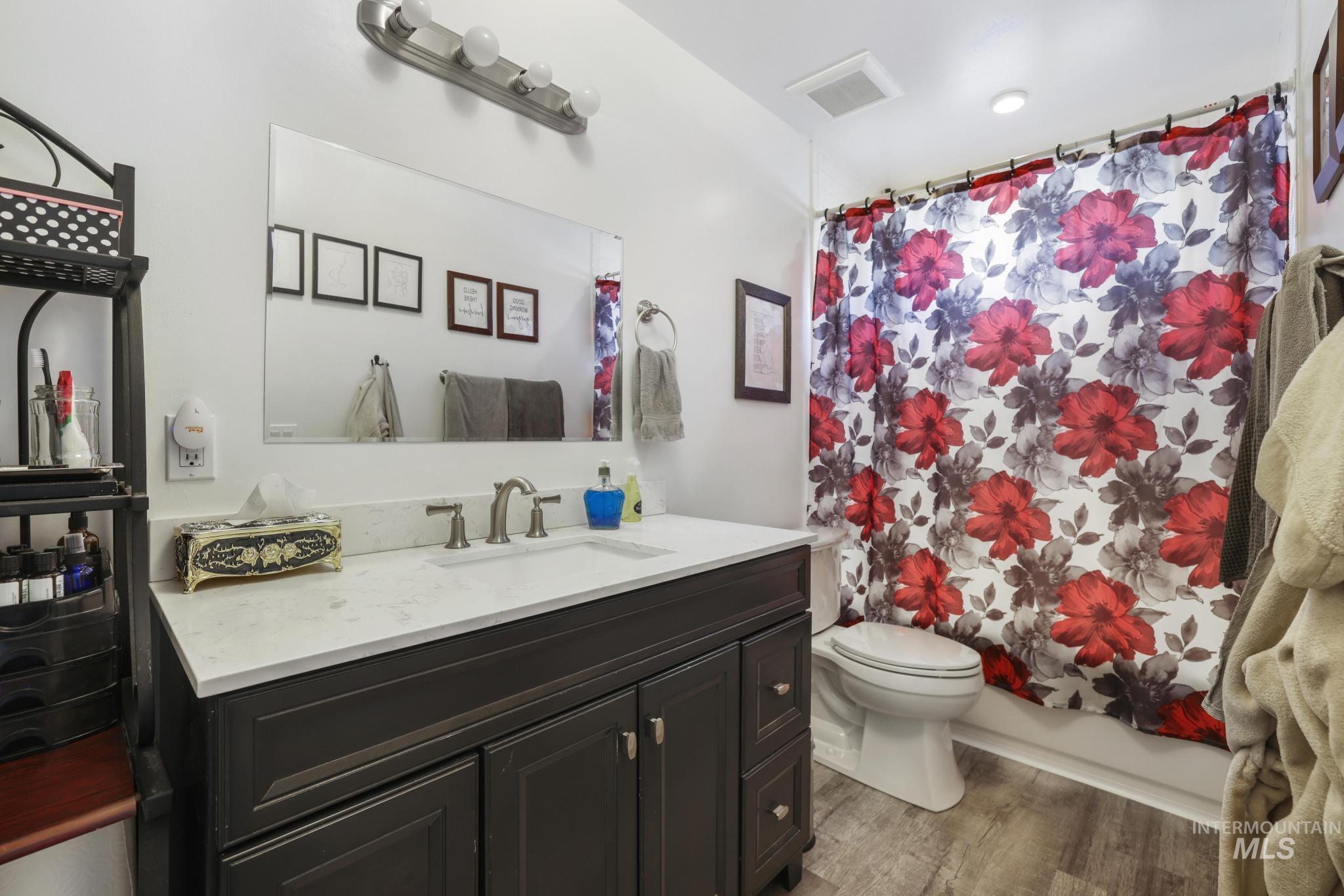 321 North 7th Street Bellevue, ID 83313 - Photo 12 of 15 Bathroom with vanity, light wood-type flooring, and shower / bath combo with shower curtain