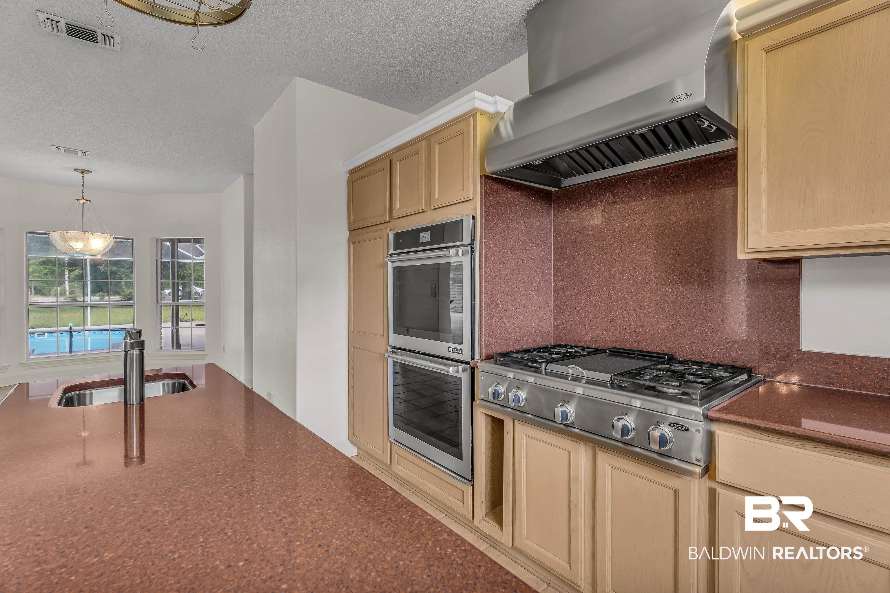 9530 Pilgrim Drive Elberta, AL 36530 - Photo 15 of 61 Kitchen with a sink, wall chimney exhaust hood, stainless steel appliances, decorative backsplash, and visible vents