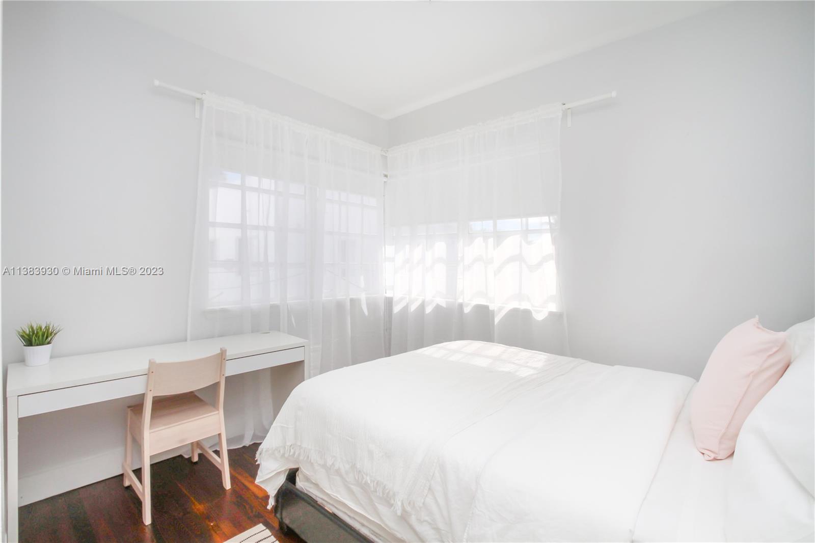 830 10th Street, Unit 3 Miami Beach, FL 33139 - Photo 12 of 22 a bedroom with a bed a table and a window