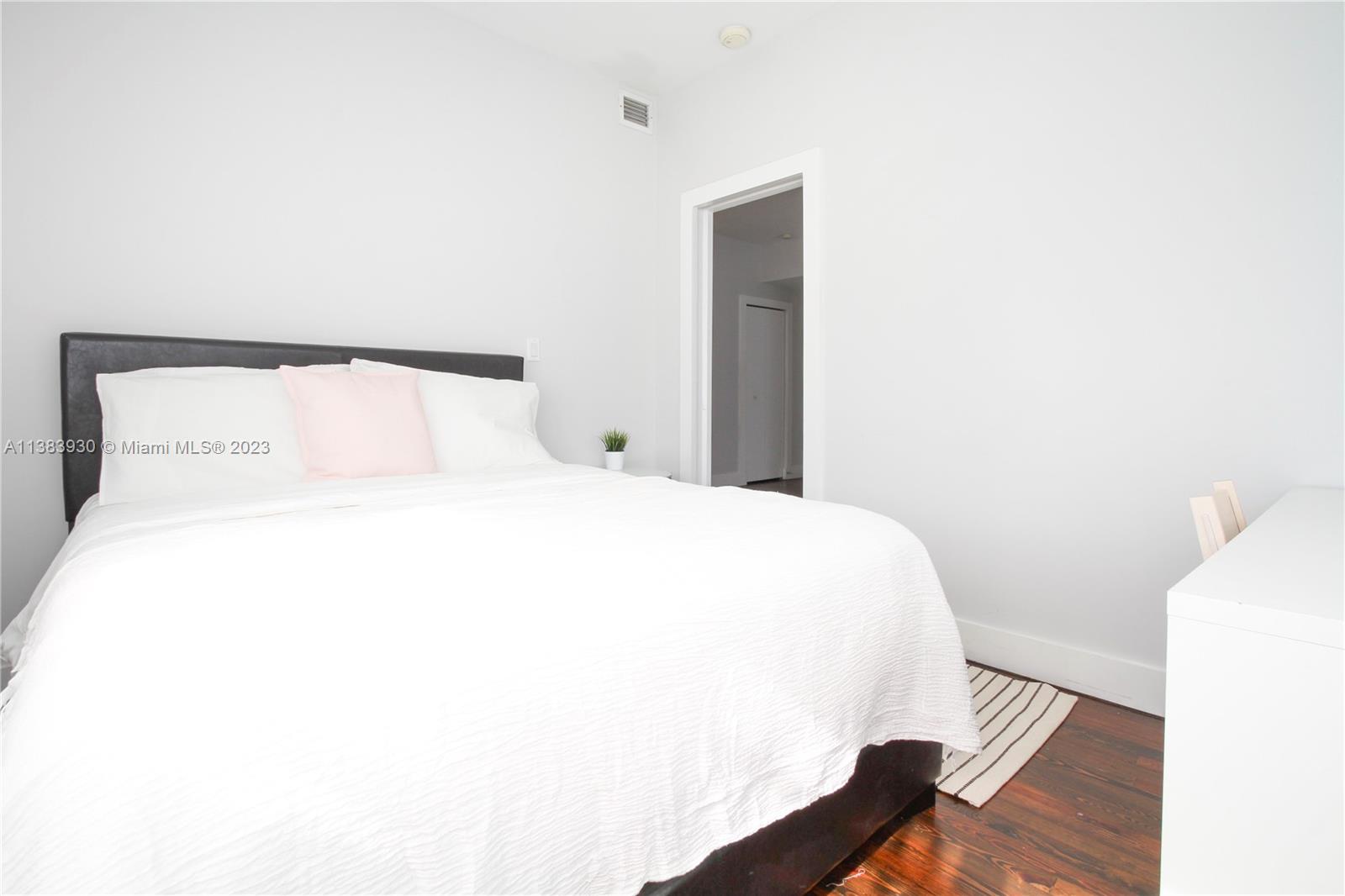830 10th Street, Unit 3 Miami Beach, FL 33139 - Photo 13 of 22 a bedroom with a bed and a night stand