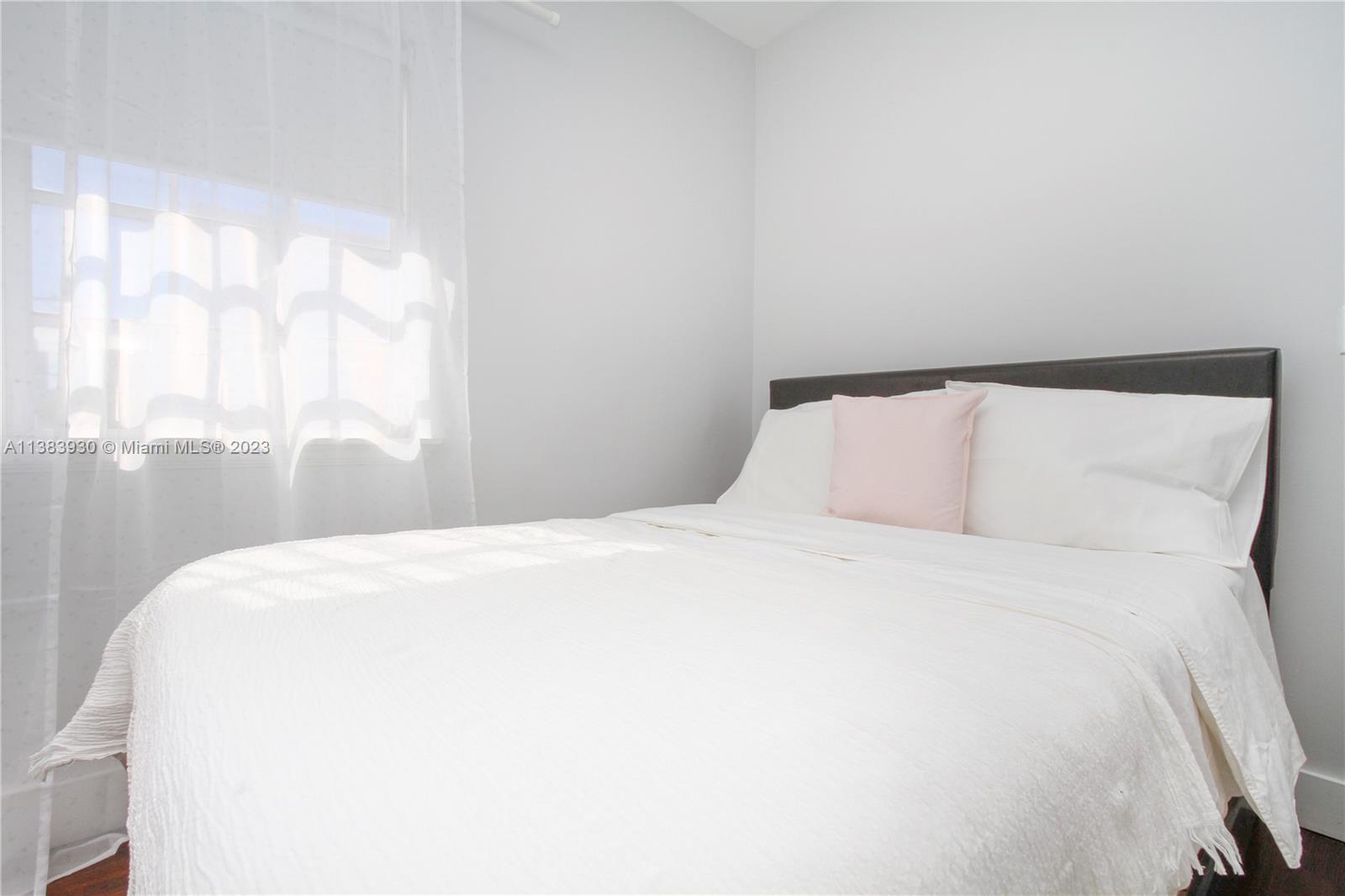 830 10th Street, Unit 3 Miami Beach, FL 33139 - Photo 14 of 22 a bedroom with a bed and a large window