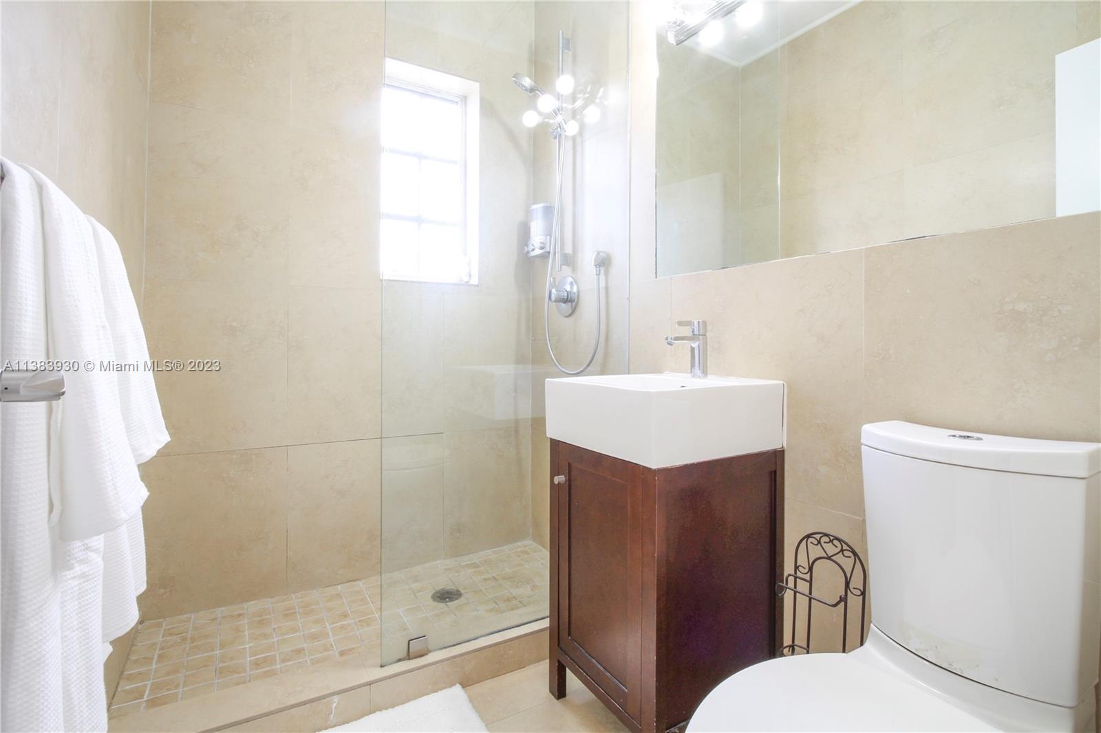 830 10th Street, Unit 3 Miami Beach, FL 33139 - Photo 15 of 22 a bathroom with a sink mirror vanity and toilet
