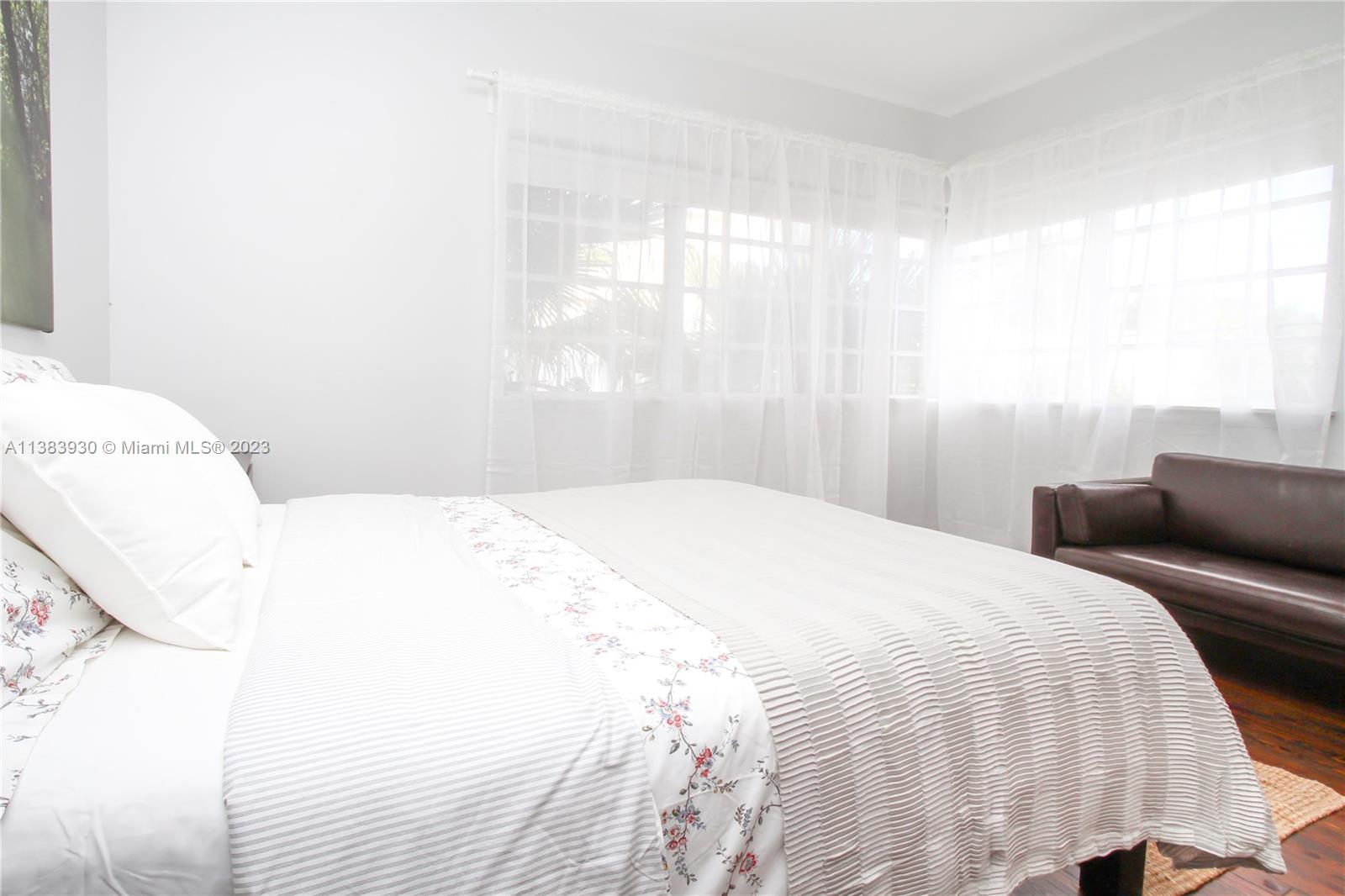 830 10th Street, Unit 3 Miami Beach, FL 33139 - Photo 18 of 22 a bedroom with a bed and a large window