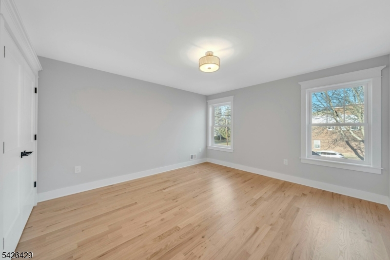 21 Spruce Street Cranford, NJ 07016 - Photo 25 of 40 an empty room with wooden floor and windows