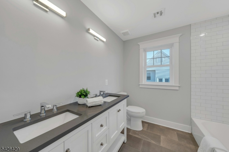 21 Spruce Street Cranford, NJ 07016 - Photo 28 of 40 a bathroom with a granite countertop sink a toilet and a mirror