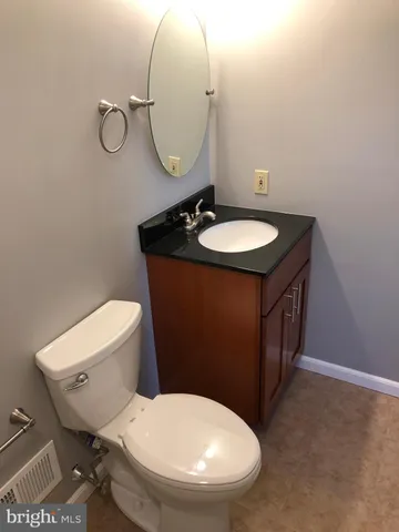 a bathroom with a toilet a sink and mirror