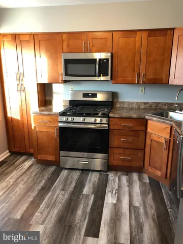 a kitchen with wooden cabinets and a stove top oven