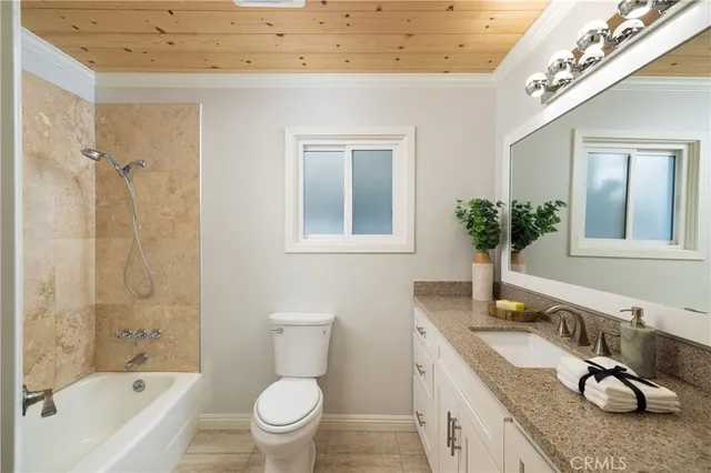 a bathroom with a granite countertop sink a toilet and shower