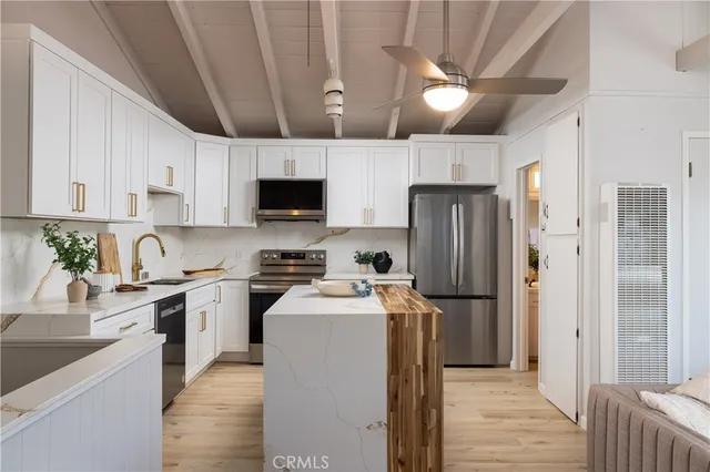 a kitchen with stainless steel appliances granite countertop a refrigerator a stove top oven a sink and dishwasher