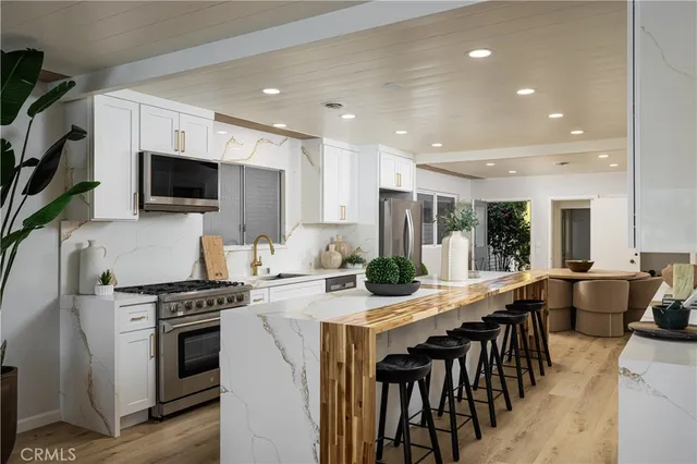 a kitchen with kitchen island granite countertop a stove and a wooden floor