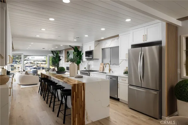 a kitchen with kitchen island a refrigerator a stove a dining table and chairs