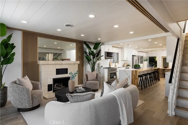 a living room with fireplace furniture and a view of kitchen