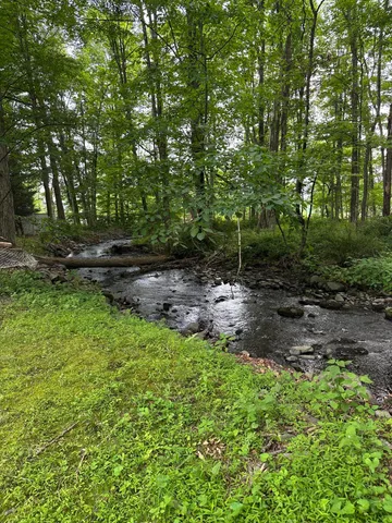 a view of a house with a yard and a wooden deck