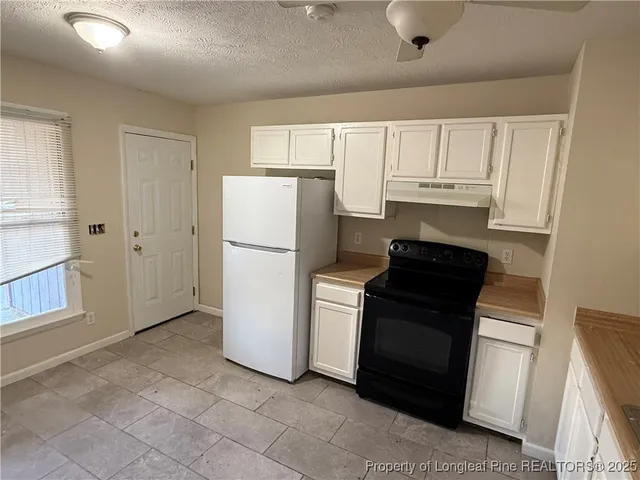 a kitchen with a refrigerator sink stove and cabinets