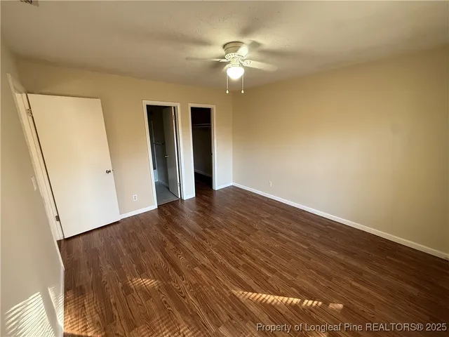 a view of a livingroom with wooden floor and a ceiling fan