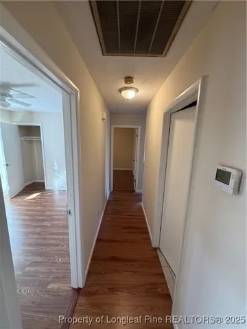 a view of a hallway with wooden floor and staircase