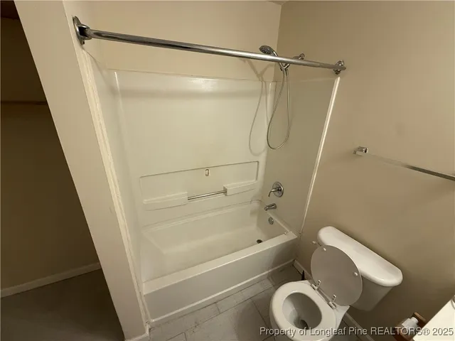 an empty room with wooden floor and fan