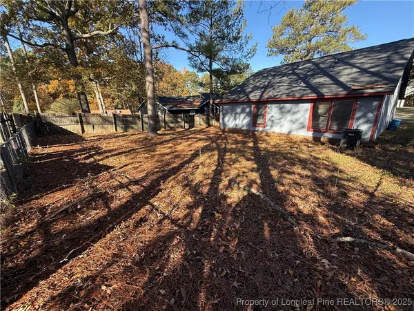 a view of a yard with plants and trees
