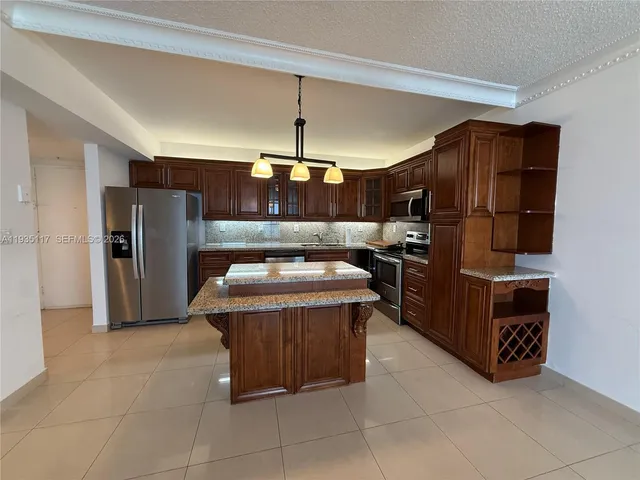 a kitchen with stainless steel appliances granite countertop a sink and a refrigerator