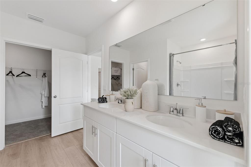 2857 House Finch Road St. Cloud, FL 34773 - Photo 28 of 70 a bathroom with a double vanity sink and mirror