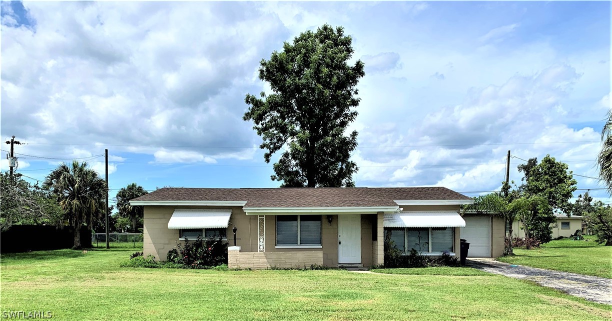 301 East Penn Road Lehigh Acres, FL 33936 - Photo 1 of 25 a front view of a house with a garden