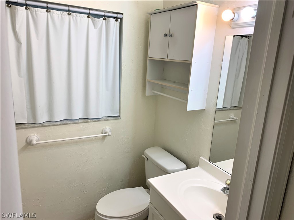 301 East Penn Road Lehigh Acres, FL 33936 - Photo 14 of 25 a white toilet sitting next to a bathroom sink