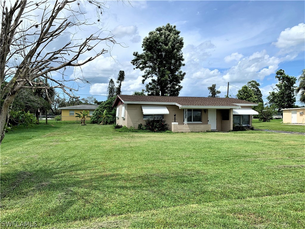 301 East Penn Road Lehigh Acres, FL 33936 - Photo 2 of 25 a front view of a house with garden