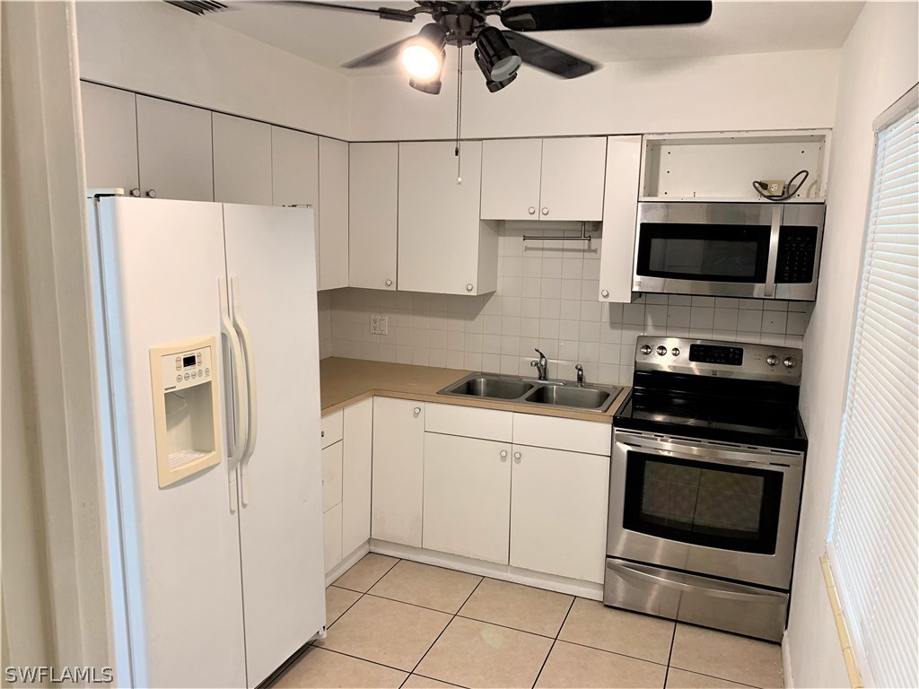 301 East Penn Road Lehigh Acres, FL 33936 - Photo 3 of 25 a kitchen with stainless steel appliances a refrigerator sink and microwave