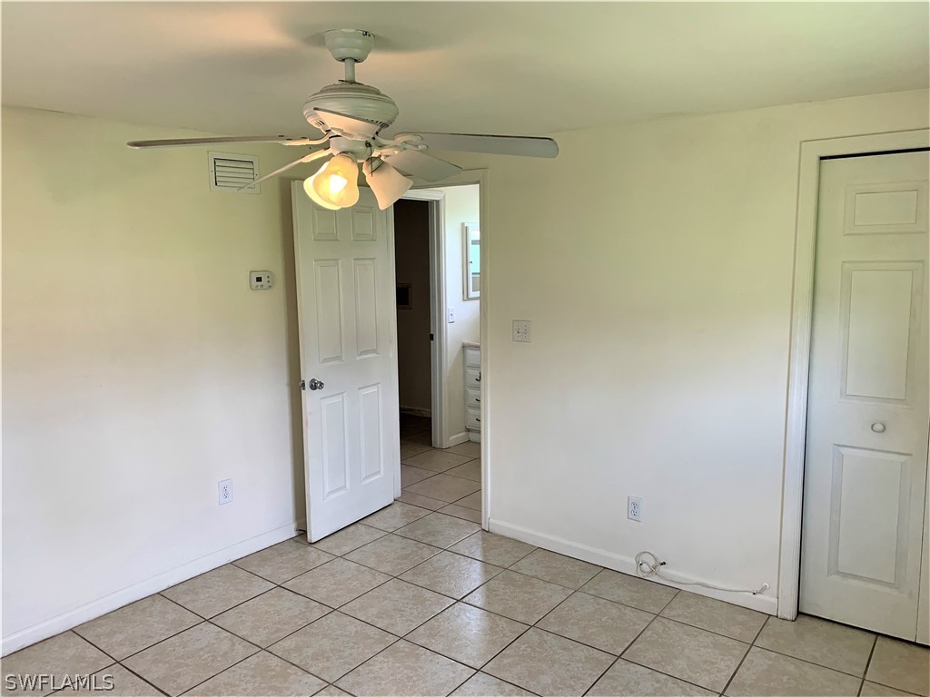 301 East Penn Road Lehigh Acres, FL 33936 - Photo 8 of 25 an empty room with a mirror and a fan