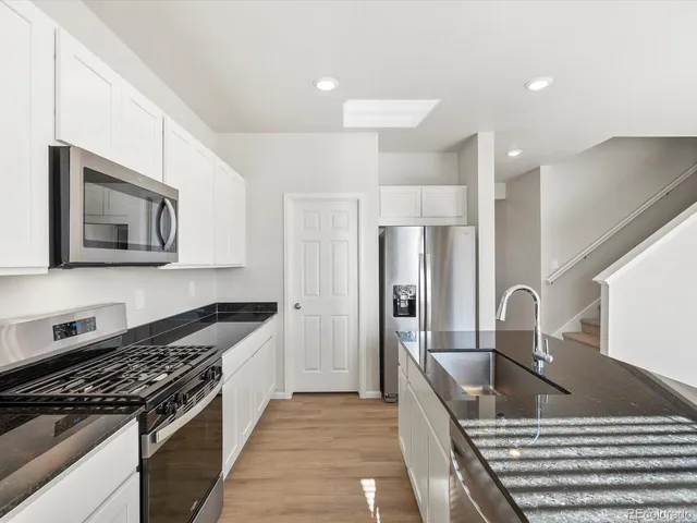 a kitchen with kitchen island granite countertop a stove and a sink
