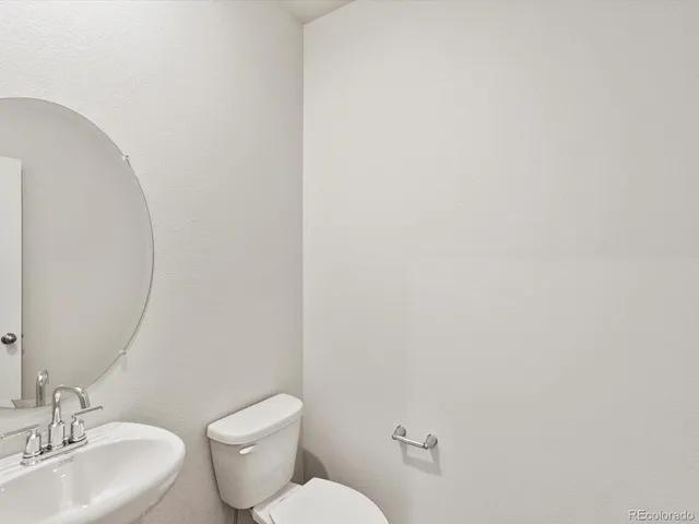 a white toilet sitting next to a bathroom sink