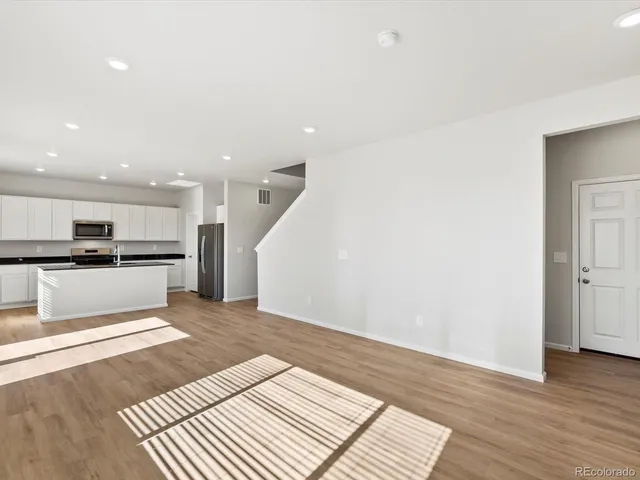 a view of kitchen with sink and refrigerator
