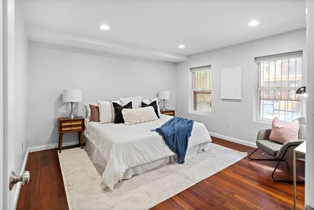 a spacious bedroom with a bed and wooden floor