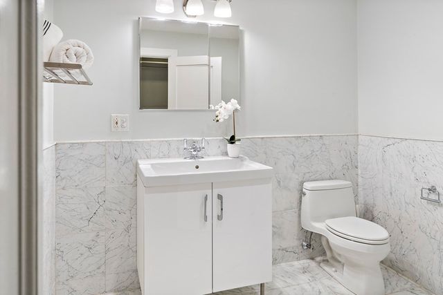 a bathroom with a toilet sink and mirror