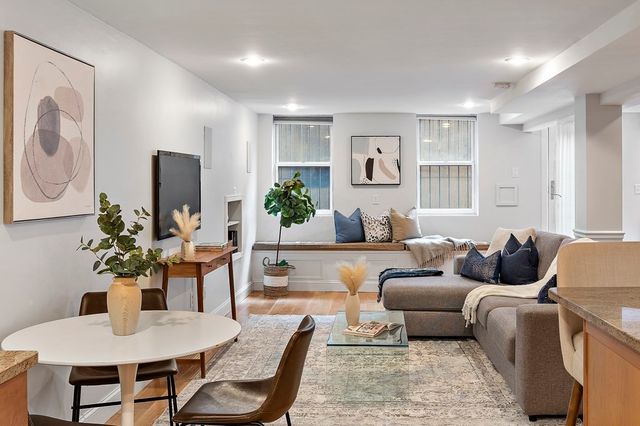a living room with furniture kitchen view and a window