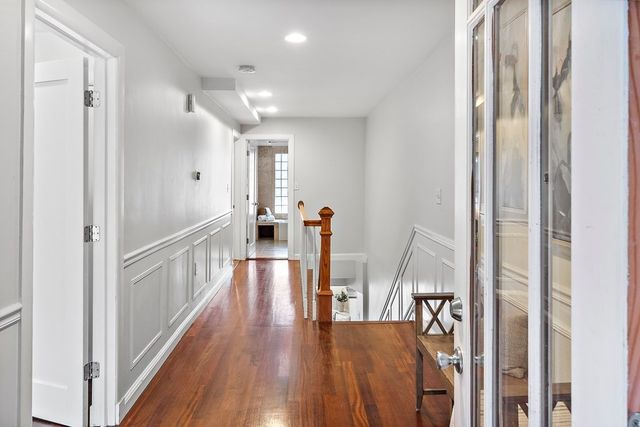 a hallway with wooden floor table and chairs