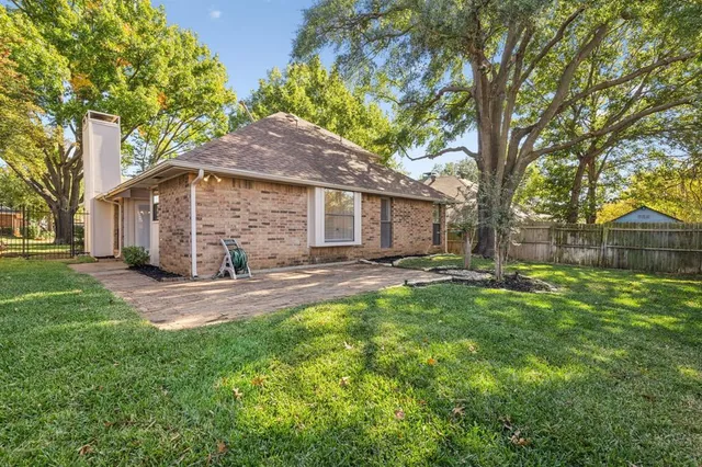 a view of a yard with a house and a large tree