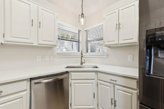 a kitchen with stainless steel appliances white cabinets and a sink