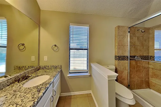 a bathroom with a granite countertop sink toilet and shower
