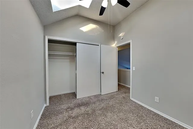 a view of an empty room and chandelier fan