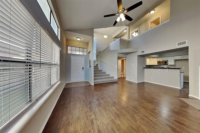 a view of a hallway with wooden floor and kitchen