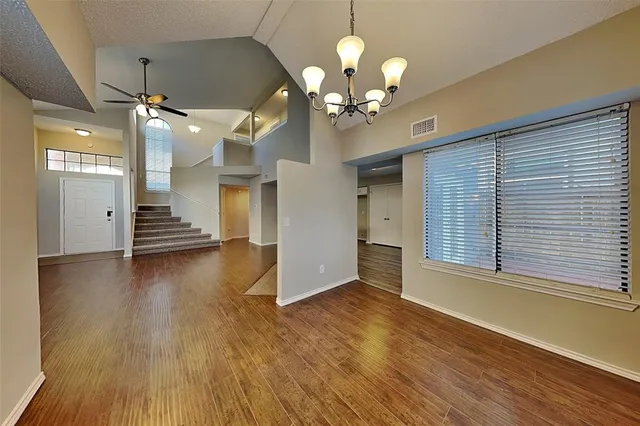 a view of a livingroom with wooden floor and staircase